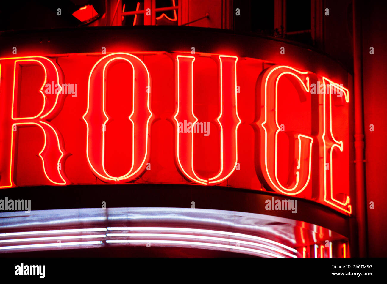 Close-up detalle del cartel de neón del cabaret Moulin Rouge, en París, Francia, por la noche - tubo fluorescente rojo - Cartas de colores saturados y Horizontal s Foto de stock
