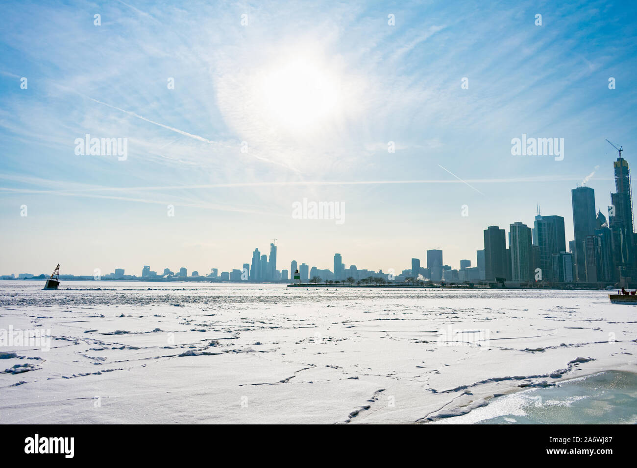 Un boya en un Frozen Lake Michigan en Chicago con el sol y el horizonte después de un Vórtice Polar Foto de stock
