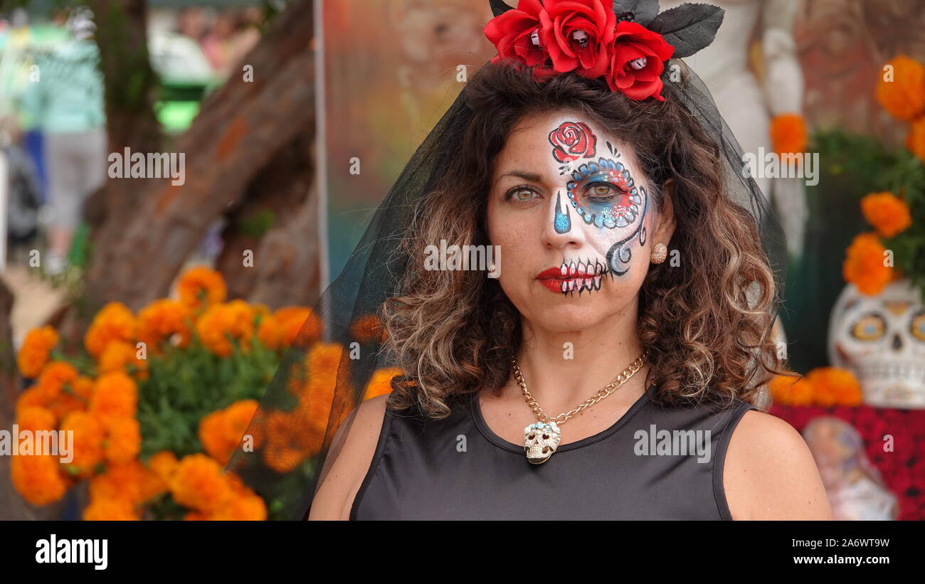 Mujer disfrazada de catrina con velo negro y arreglo floral en la cabeza,  en calles del centro histórico de la ciudad de México. Stock Photo