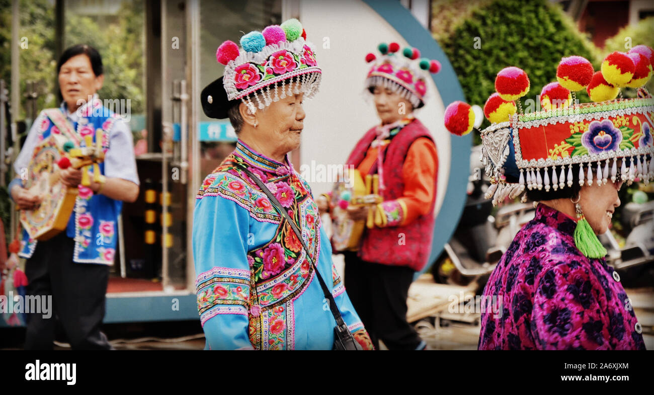 Las minorías étnicas chinas vistiendo su atuendo tradicional realizar antiguas danzas étnicas en Kunming, la capital de China del sur de la provincia de Yunnan. Foto de stock