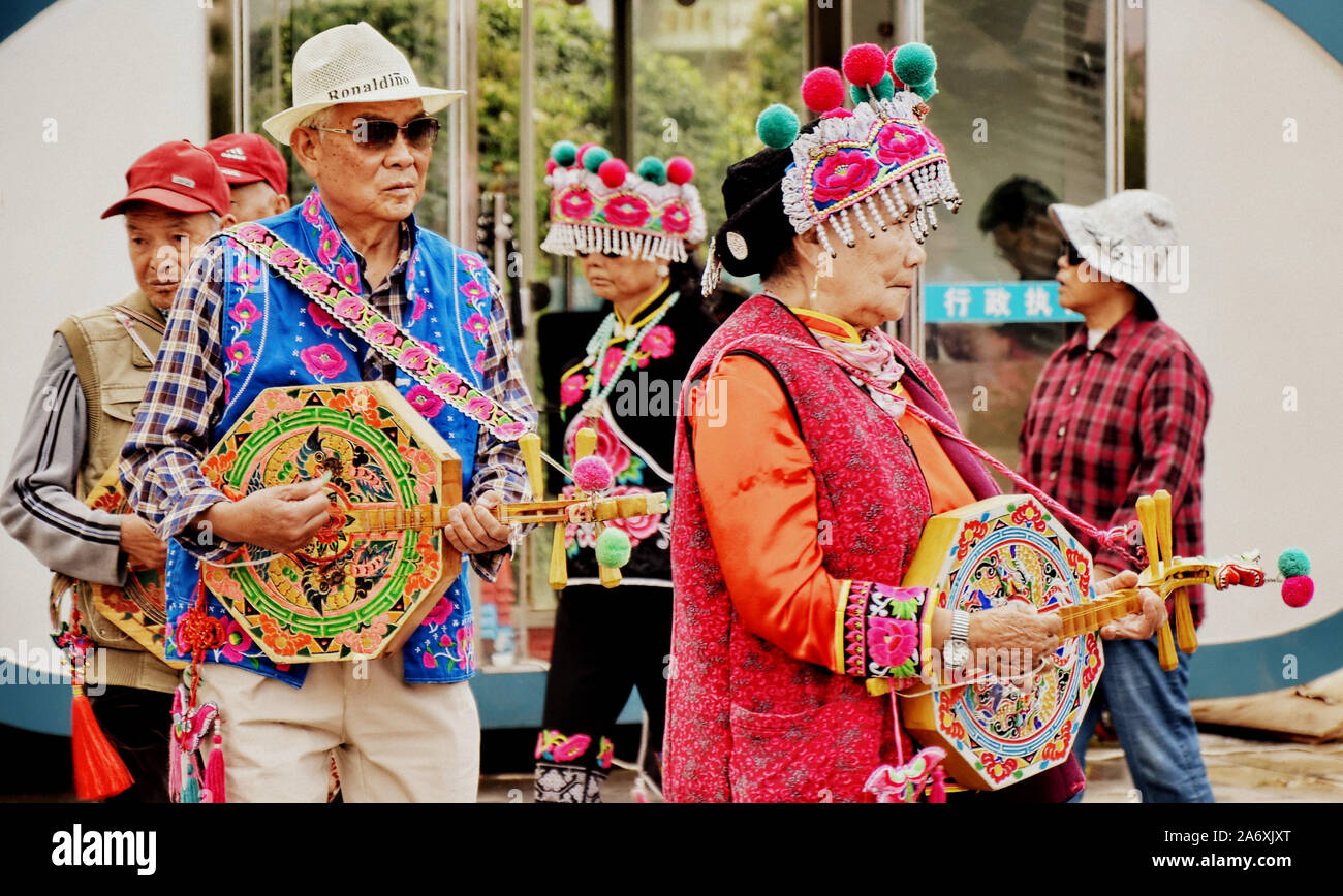 Las minorías étnicas chinas vistiendo su atuendo tradicional realizar antiguas danzas étnicas en Kunming, la capital de China del sur de la provincia de Yunnan. Foto de stock