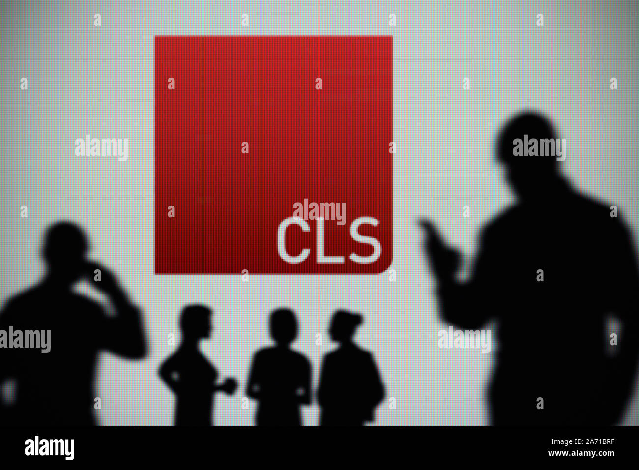 El CLS Holdings logotipo es visto en una pantalla LED en el fondo mientras una silueta persona utiliza un smartphone (uso Editorial solamente) Foto de stock