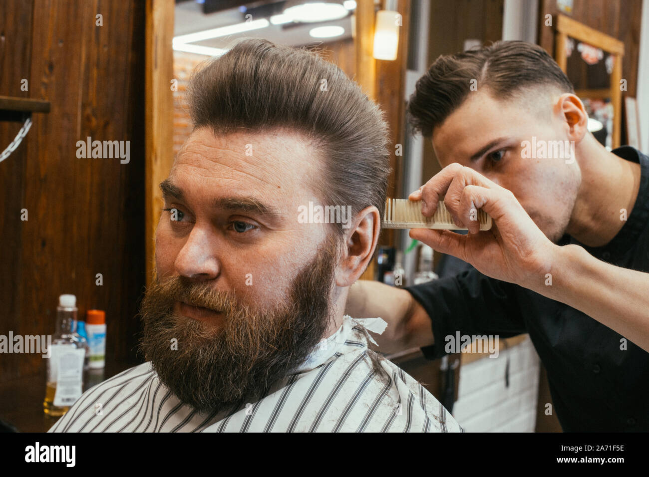 Barber shop, un hombre con una barba corta peluquería. Un pelo bonito y cuidado, peluquería para hombres. Corte de pelo profesional, peinado y estilo retro. Custo Foto de stock