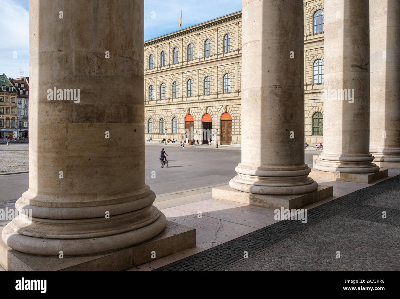 Munich, Baviera, Alemania. Tesoro de el edificio de la residencia de Munich Max Joseph Platz, vistos a través de las columnas del edificio del Teatro Nacional. Foto de stock