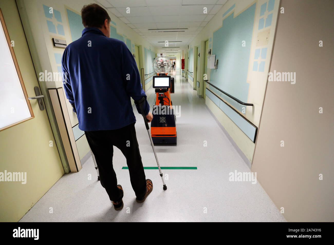 29 de octubre de 2019, Turingia, Eisenberg: Un paciente se entrena con la  ayuda de Ringo, un robot, caminando por un pasillo en el hospital  Waldkliniken Eisenberg. En un proyecto de investigación