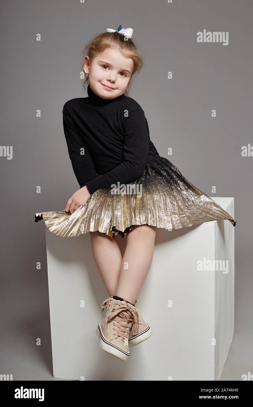 Chica el cabello de moda en ropa casual sentado en un cubo blanco y posando. Hermosa niña. Rusia, Sverdlovsk, 4 de febrero de 2018 Fotografía de stock - Alamy