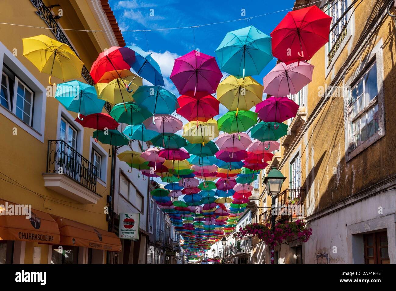Calle cubierta por paraguas de multiples colores en Portugal