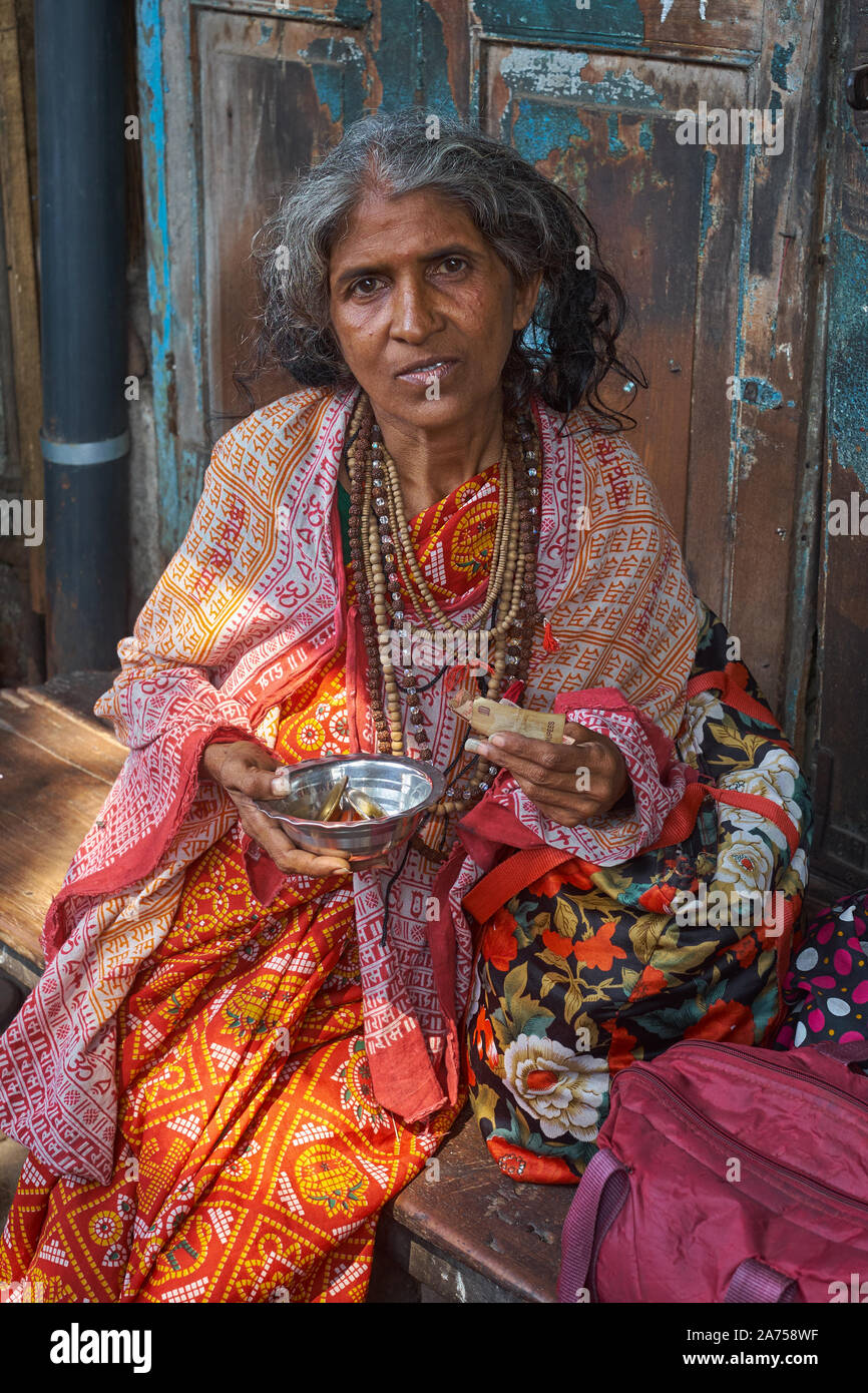 Un colorido, extravagantemente vestidos femeninos renunciate hindú, con collares de semillas de Rudraksha santo, pidiendo limosna en Mumbai, India Foto de stock