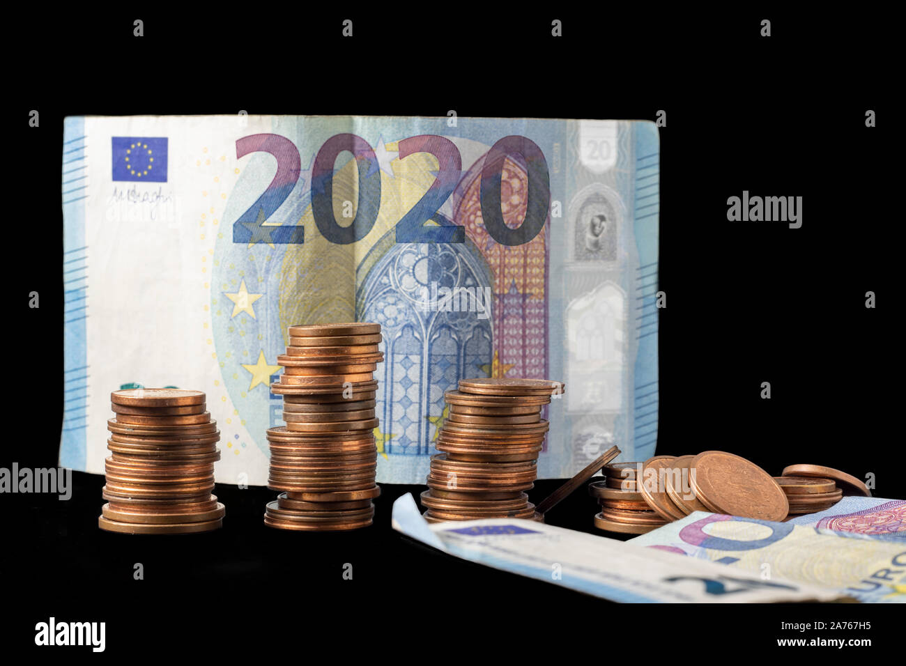 Nuevo año fiscal 2020 representó con montones de monedas y billetes en euros aislados en negro. Imagen conceptual de la situación económica y la posible futura Foto de stock
