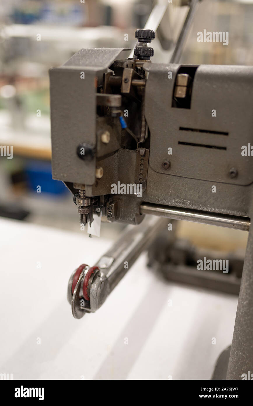 Máquina para suavizar las piezas y pegar la cinta. La fabricación de zapatos. Foto de stock