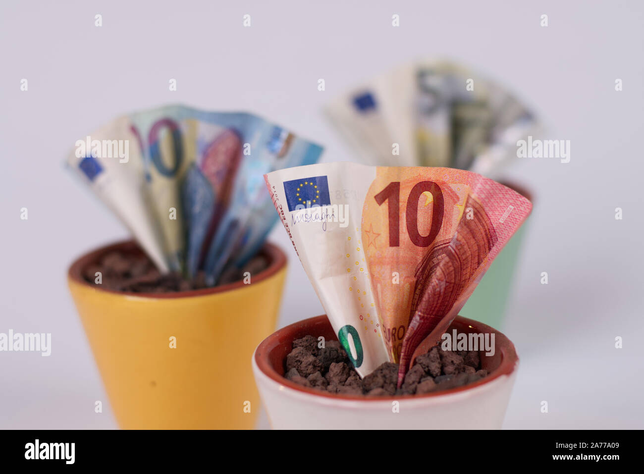 Cómo hacerse rico rápidamente? Simpel: Planta algunos billetes, seriamente, invirtiendo su euro's es una idea mejor. Estas ollas de dinero simboliza su inversión. Foto de stock