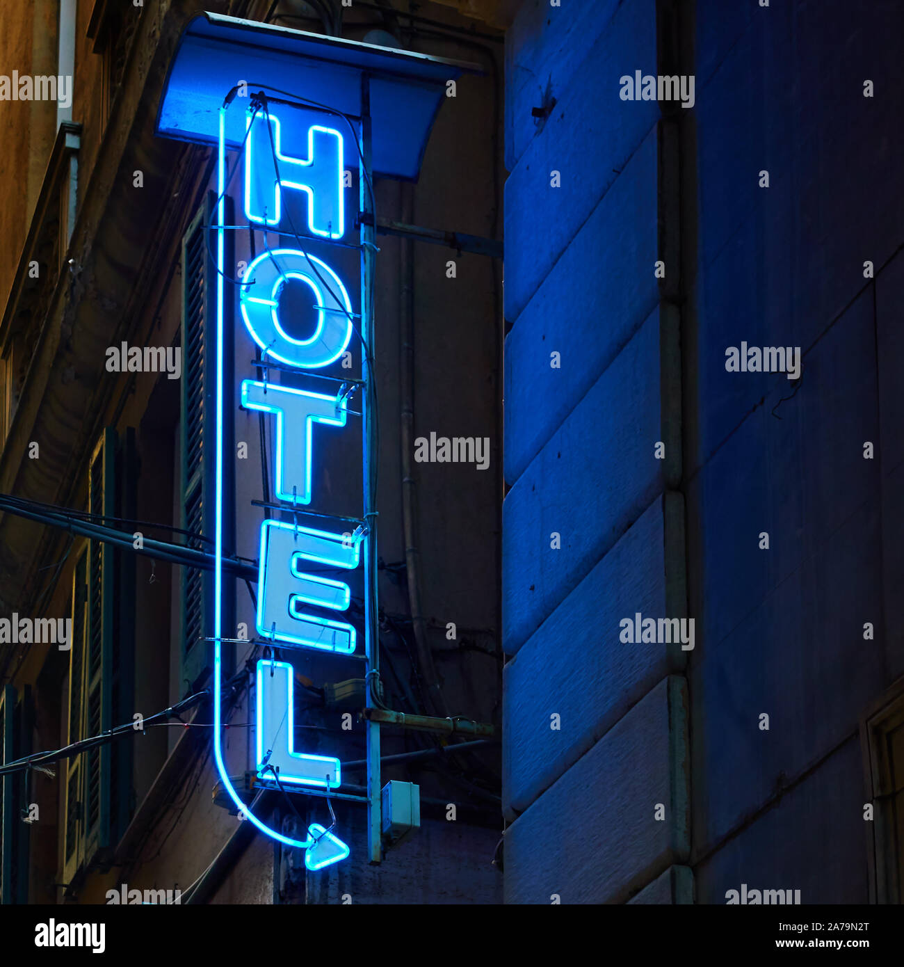 Neon hotel cartel en la pared en la noche Foto de stock