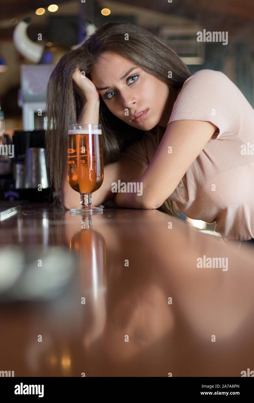 Chica en un bar tomando una cerveza Fotografía de stock - Alamy