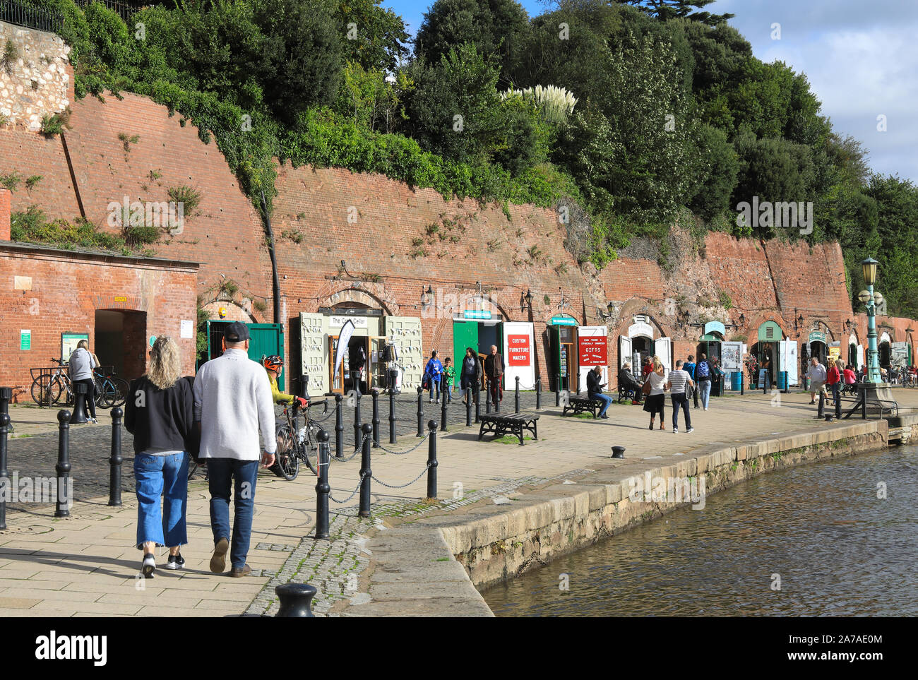 Sol de otoño en las tiendas independientes ahora en los viejos arcos de ladrillo de almacenes del siglo XIX, en la histórica zona de Quayside en Exeter, en Devon, Reino Unido Foto de stock