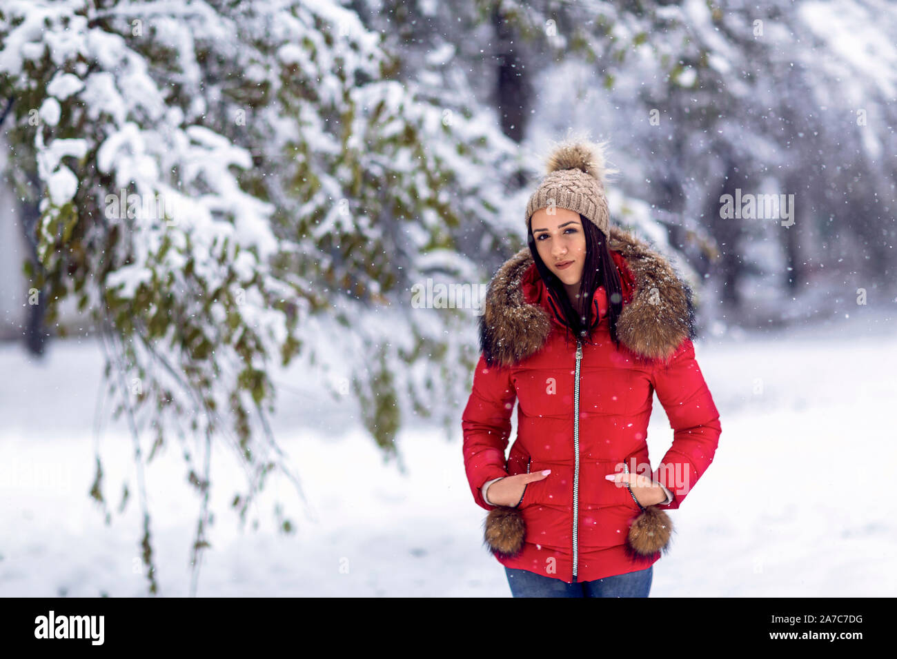 Feliz joven en ropa de invierno en un día frío con nieve Foto de stock