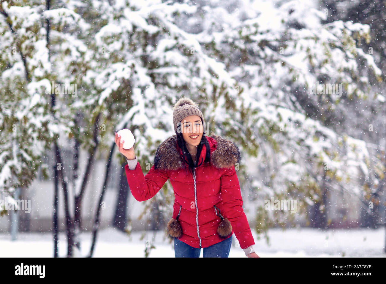 Magia en invierno la nieve.Feliz mujer arrojar snowball jugando con nieve en día de invierno. Foto de stock