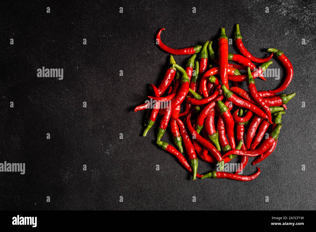 Pimiento rojo brillante sobre un fondo de cemento gris. La comida picante, ingredientes. Esto puede ser utilizado como fondo Foto de stock