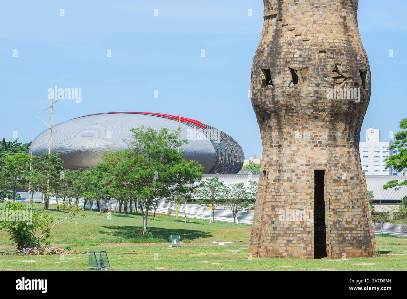 Campo Grande - MS, Brasil - 30 de octubre de 2019: Los indígenas Zarabatana monumento en el Parque de las Naciones Indígenas y el moderno edificio del Pantanal aqu Foto de stock