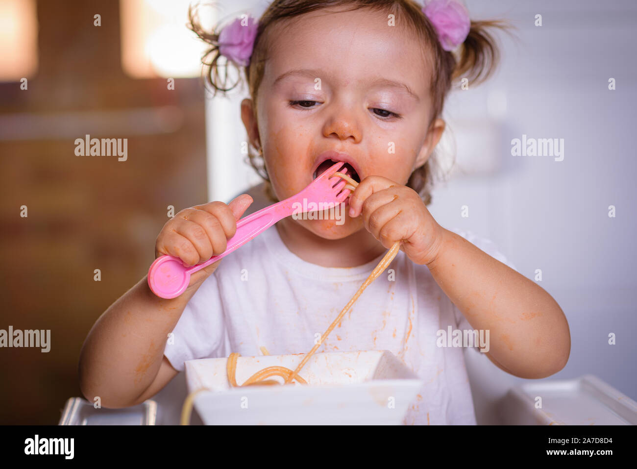 Cute Little Funny Girl De 18 Meses 1 Ano De Edad El Bebe Nina Sentada En Una Silla Alta Potencia En Casa Come Fideos Con Cuchara Y Tenedor Foto Dentro Fotografia