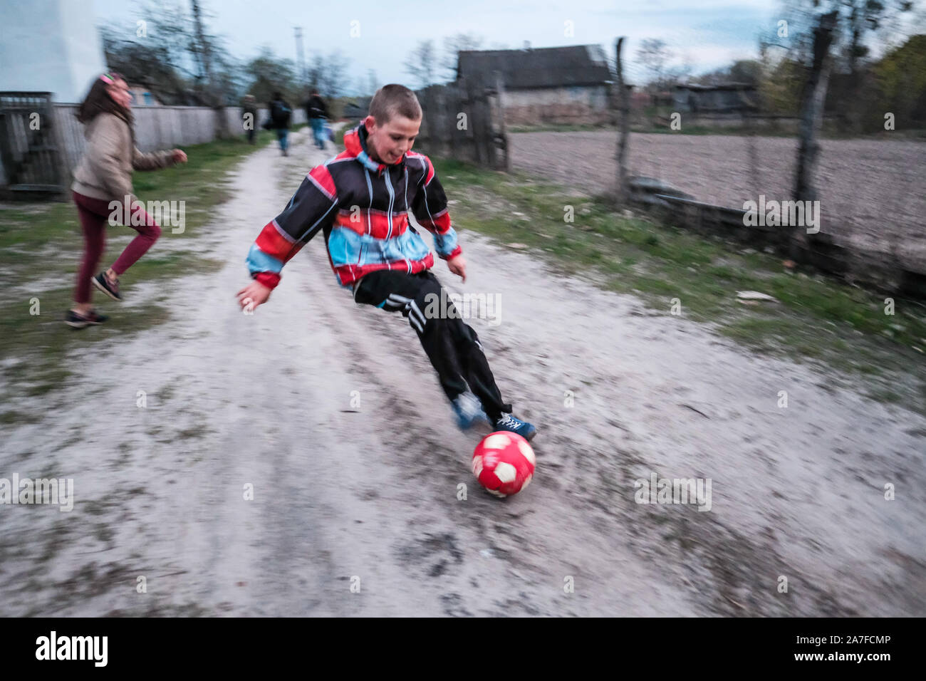 Dos niños juegan al fútbol en el interior de la zona de exclusión de Chernobyl. Ucrania Foto de stock
