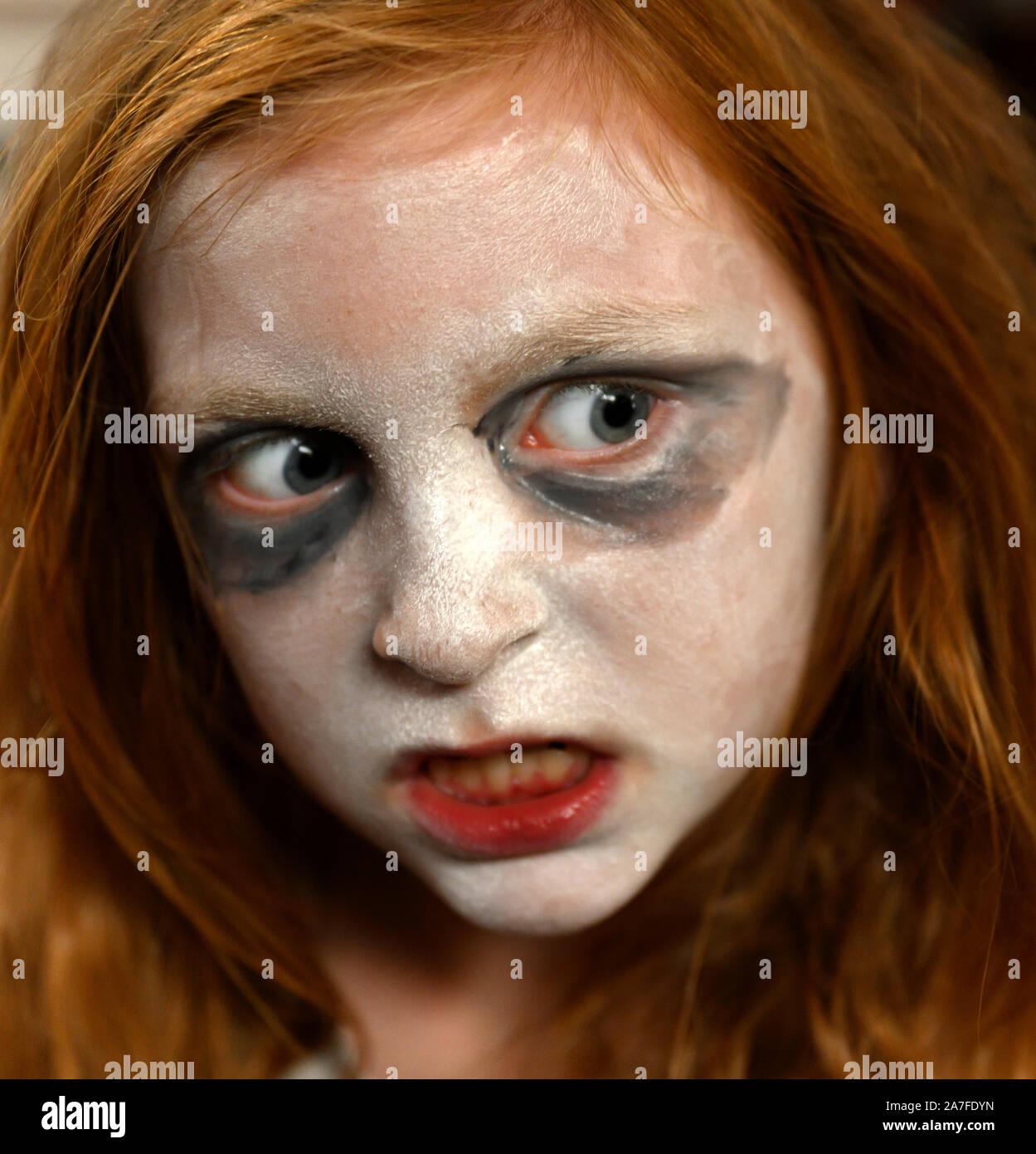 Vertical - blanco joven chica inglesa listo para la fiesta de Halloween con pintura facial y maquillaje con apariencia exagerada. Foto de stock