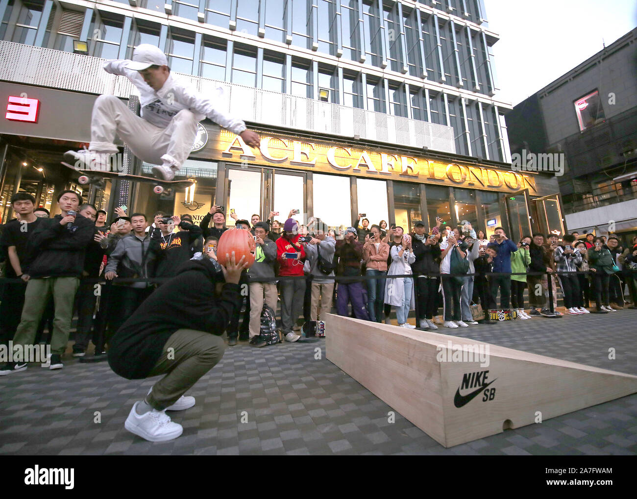 Beijing, China. 02Nd Nov, 2019. Un chino skate boarder, patrocinado por Nike  para promocionar su nueva línea de zapatos, realiza acrobacias en frente de  una multitud en un centro comercial internacional en