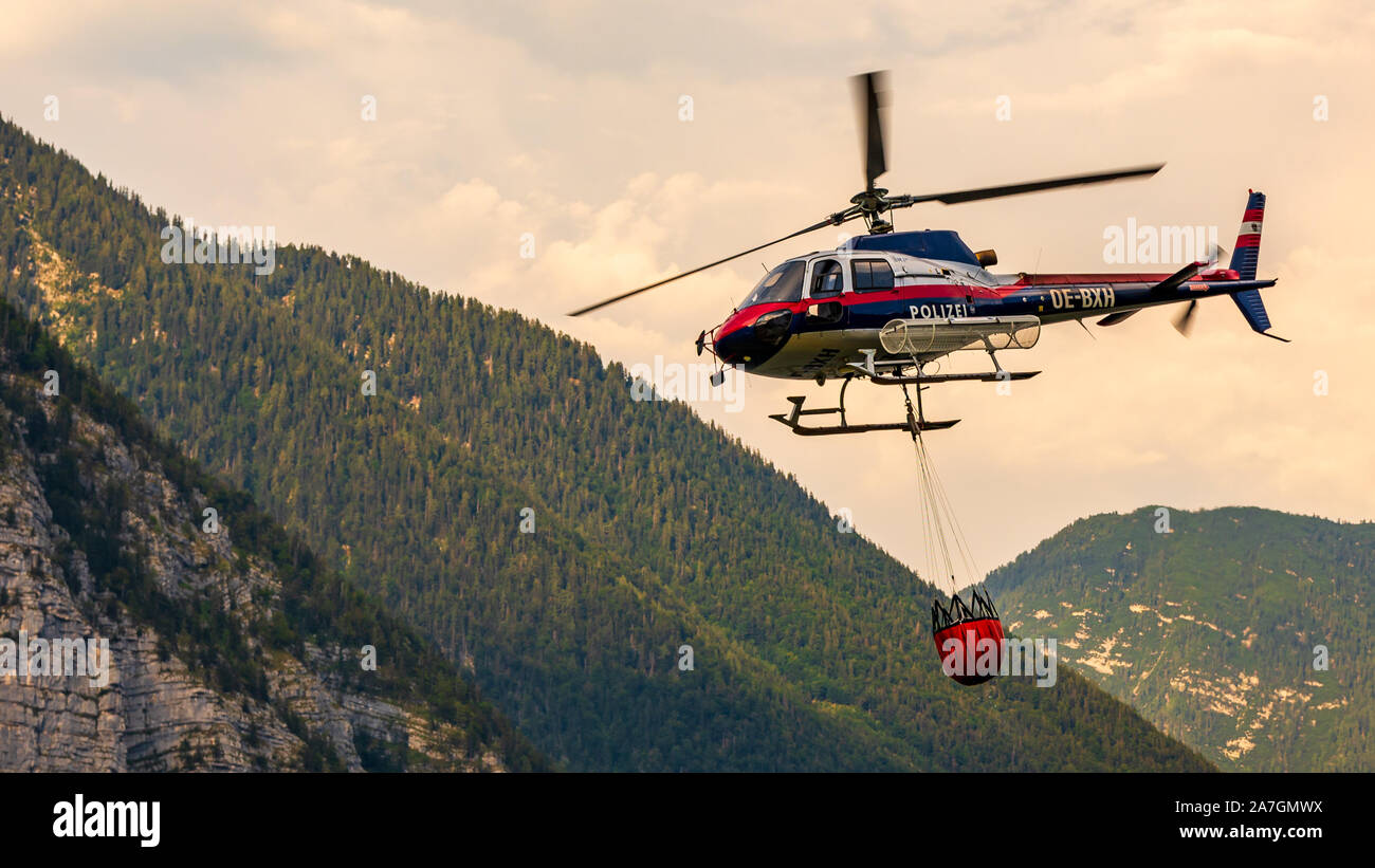 En Hallstatt, partside Firemans del lago. El helicóptero está sacando agua del lago. Foto de stock