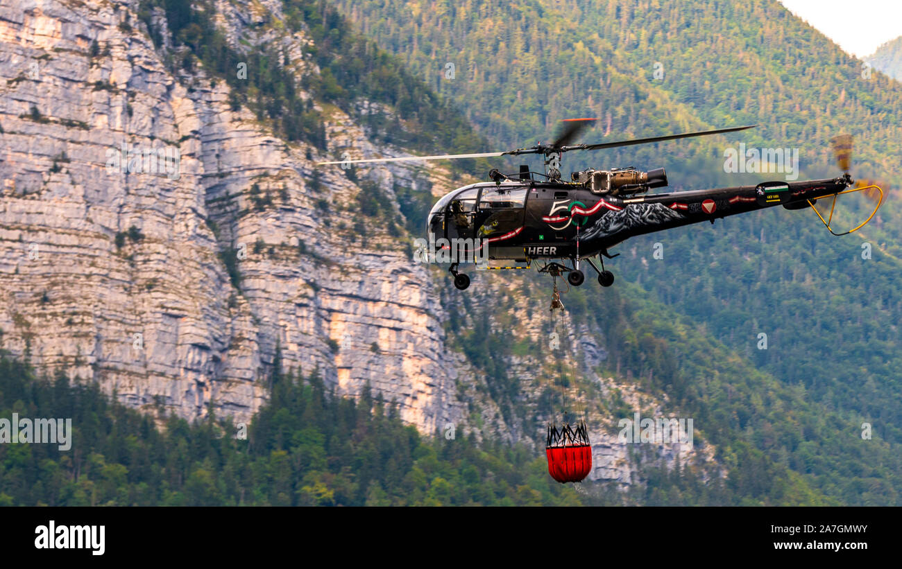 En Hallstatt, partside Firemans del lago. El helicóptero está sacando agua del lago. Foto de stock