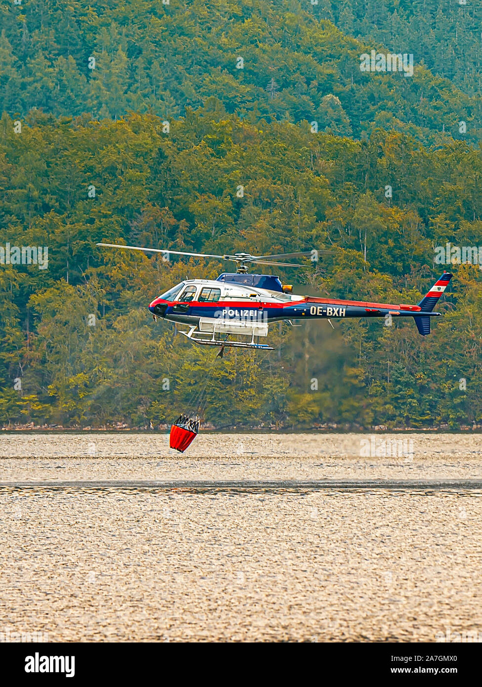 En Hallstatt, partside Firemans del lago. El helicóptero está sacando agua del lago. Foto de stock