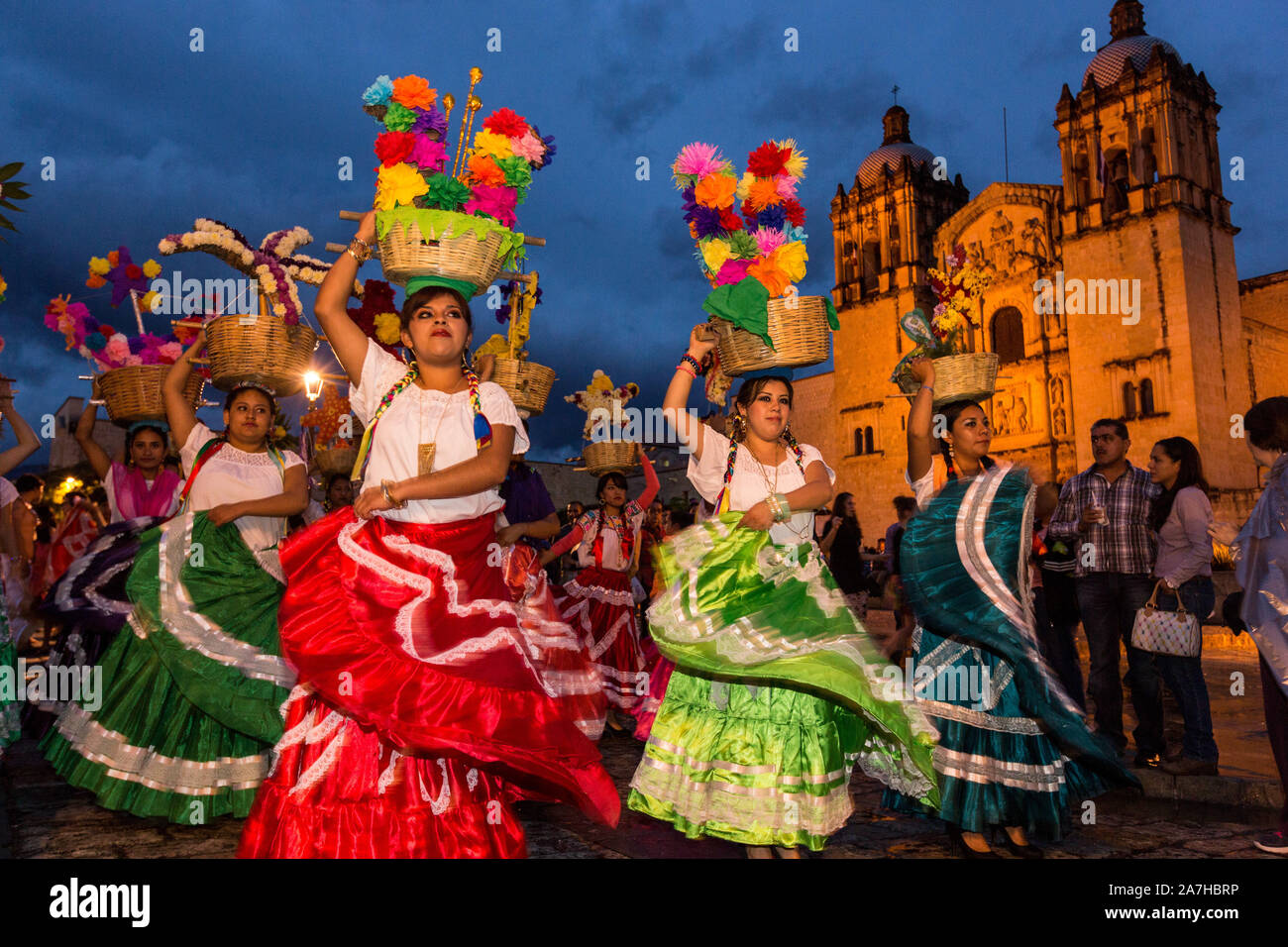 Las mujeres jóvenes vestidas en trajes tradicionales y realizar la Flor de  Pina bailan en comparsas pasada la iglesia de Santo Domingo de Guzmán  durante el día de los Muertos Festival conocido