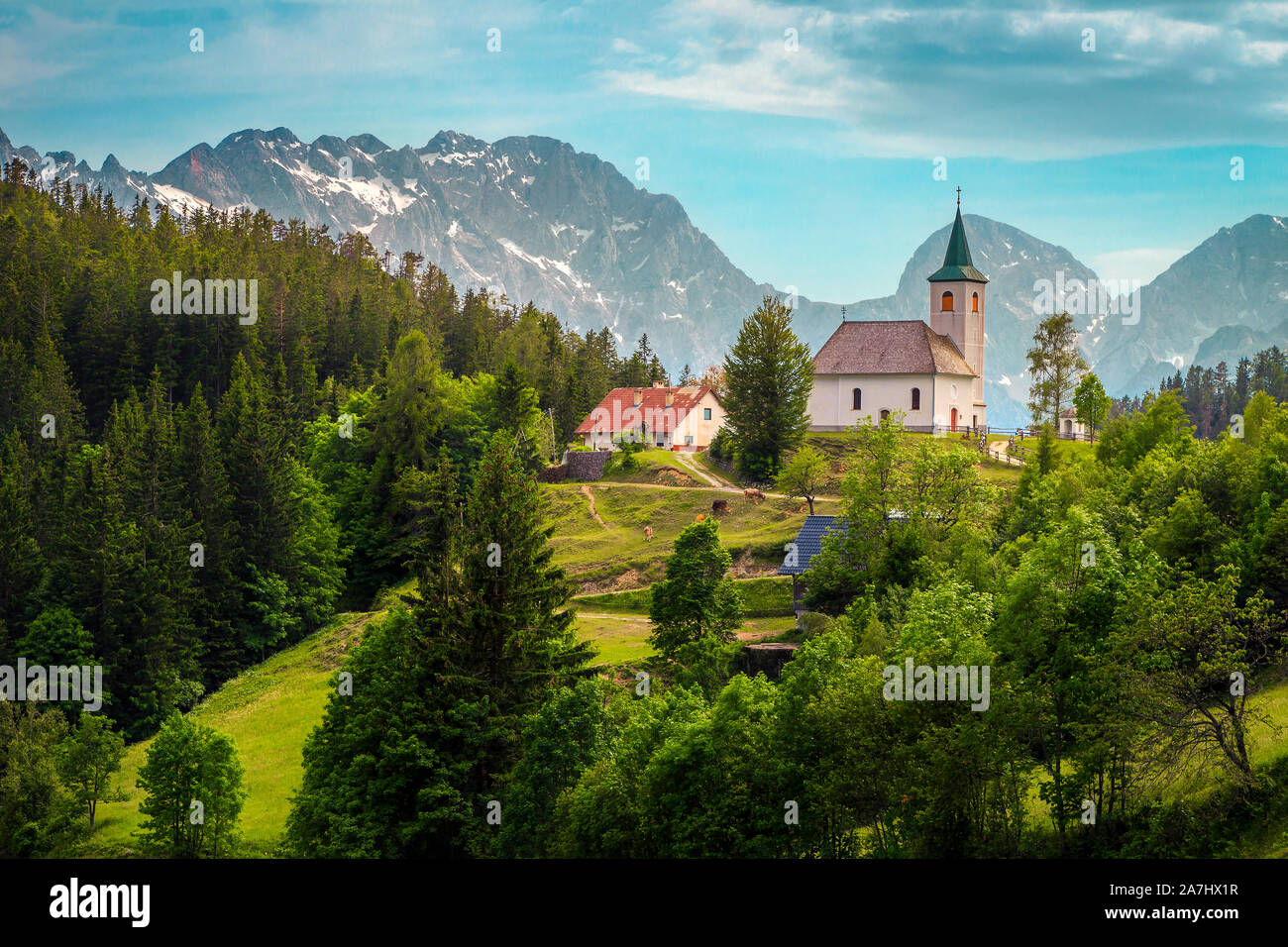 Paisaje de montaña eslovena con la iglesia. St Espíritu ( Sveti Duh) iglesia en la cresta de la montaña y de los Alpes de Kamnik-Savinja antecedentes, Eslovenia, Europa Foto de stock