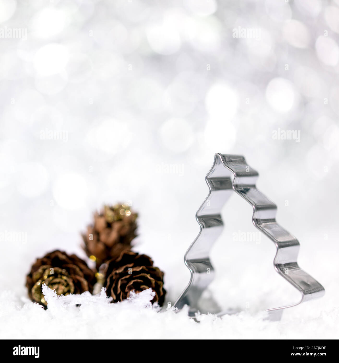 Árbol de Navidad Cortador giratorio y el abeto conos con copos de nieve, fondo de invierno Foto de stock