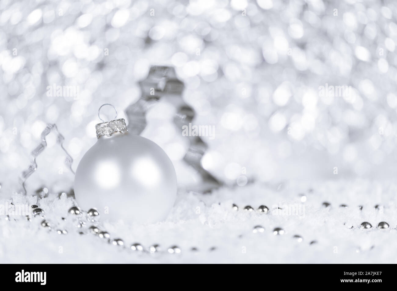Cortador de abeto, y adornos de perlas en color blanco y plata, copos de nieve en la parte delantera Foto de stock