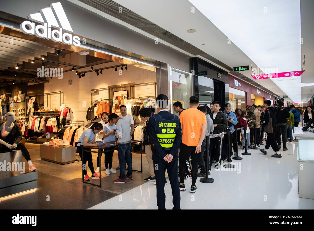 Línea de los consumidores a comprar el recién liberado Adidas Yeezy, una  colaboración entre la marca de ropa deportiva alemana Adidas y rapero  estadounidense Kanye West, en un Fotografía de stock -