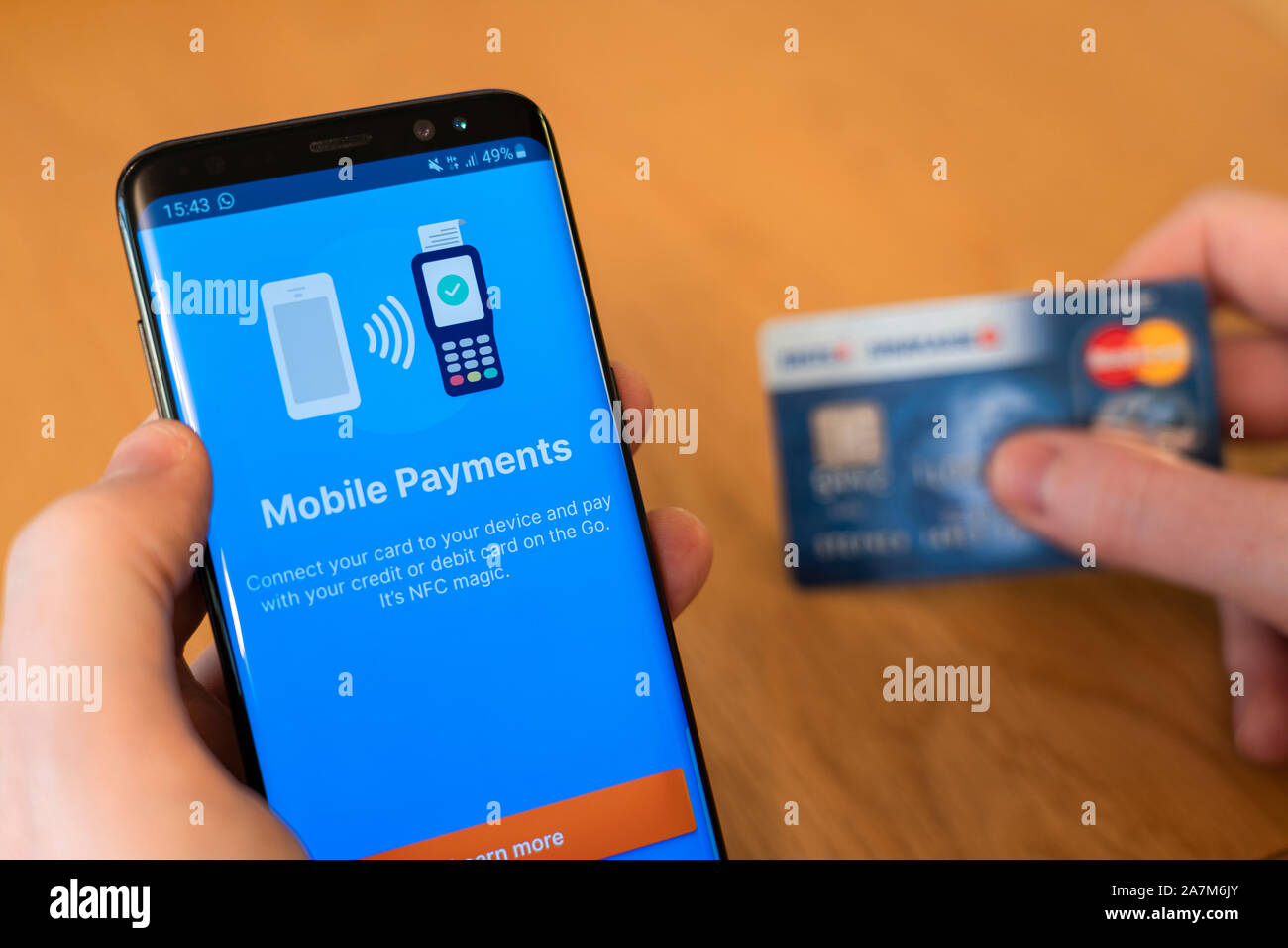 Utilizando un teléfono móvil para realizar un pago con tarjeta de crédito en línea. Concepto - pagos móviles y fraude Foto de stock