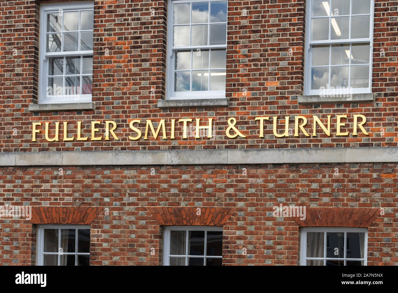 Un Fuller smith y turner pub firmar sobre un fondo de ladrillo Foto de stock