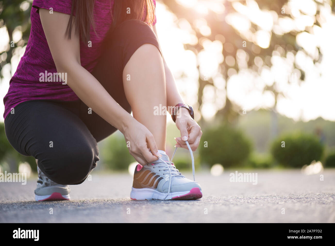Zapatillas de correr: mujer que ata los cordones de los zapatos, un  corredor deportivo que se prepara para correr en el jardín.