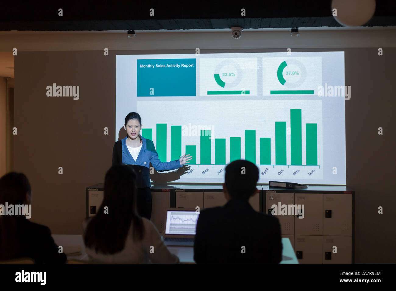 Fotografía de una joven empresaria en businesswear dando una presentación con un gráfico en la pantalla detrás de ella Foto de stock