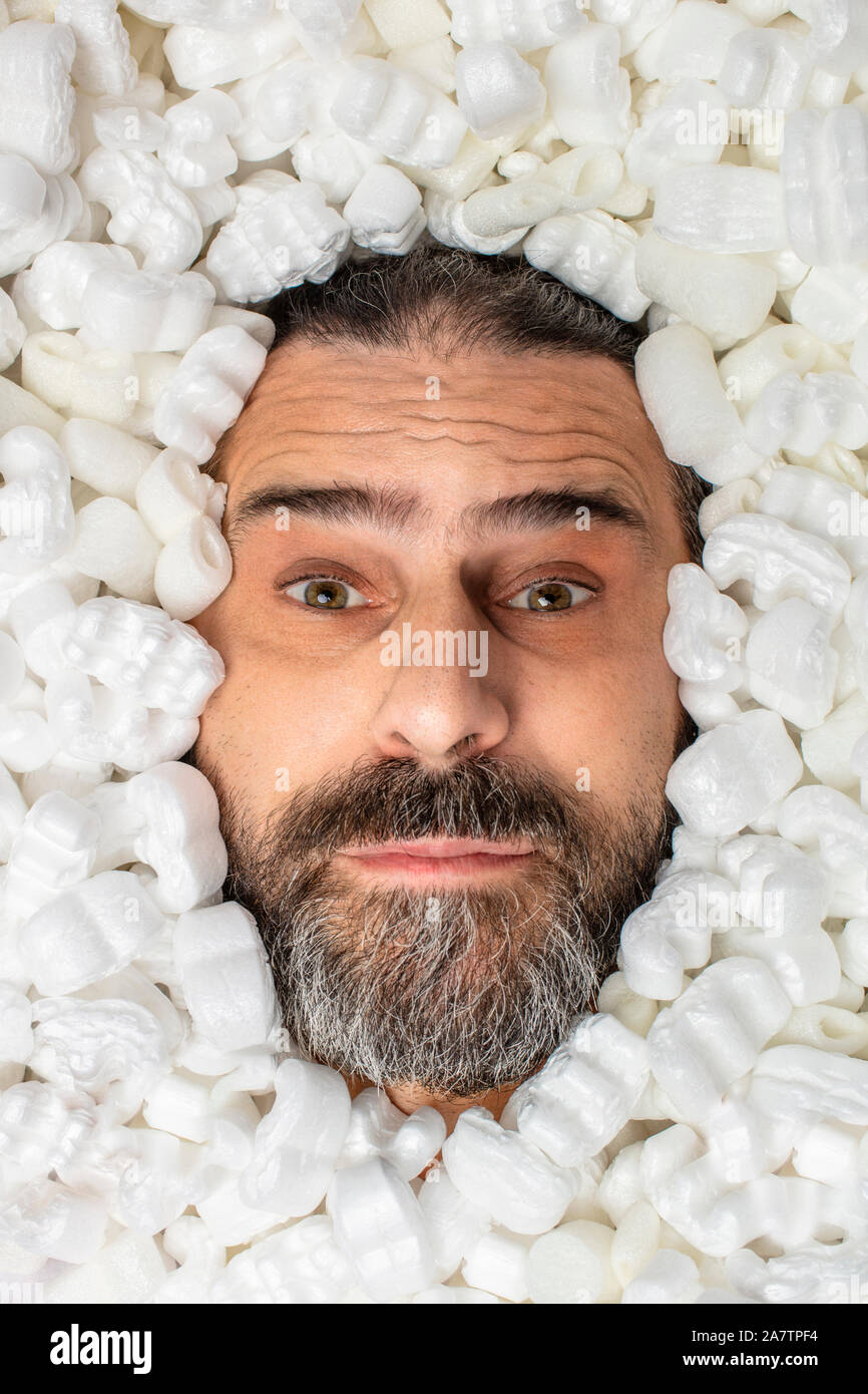 Retrato de un hombre cubierto en embalajes de poliestireno Foto de stock