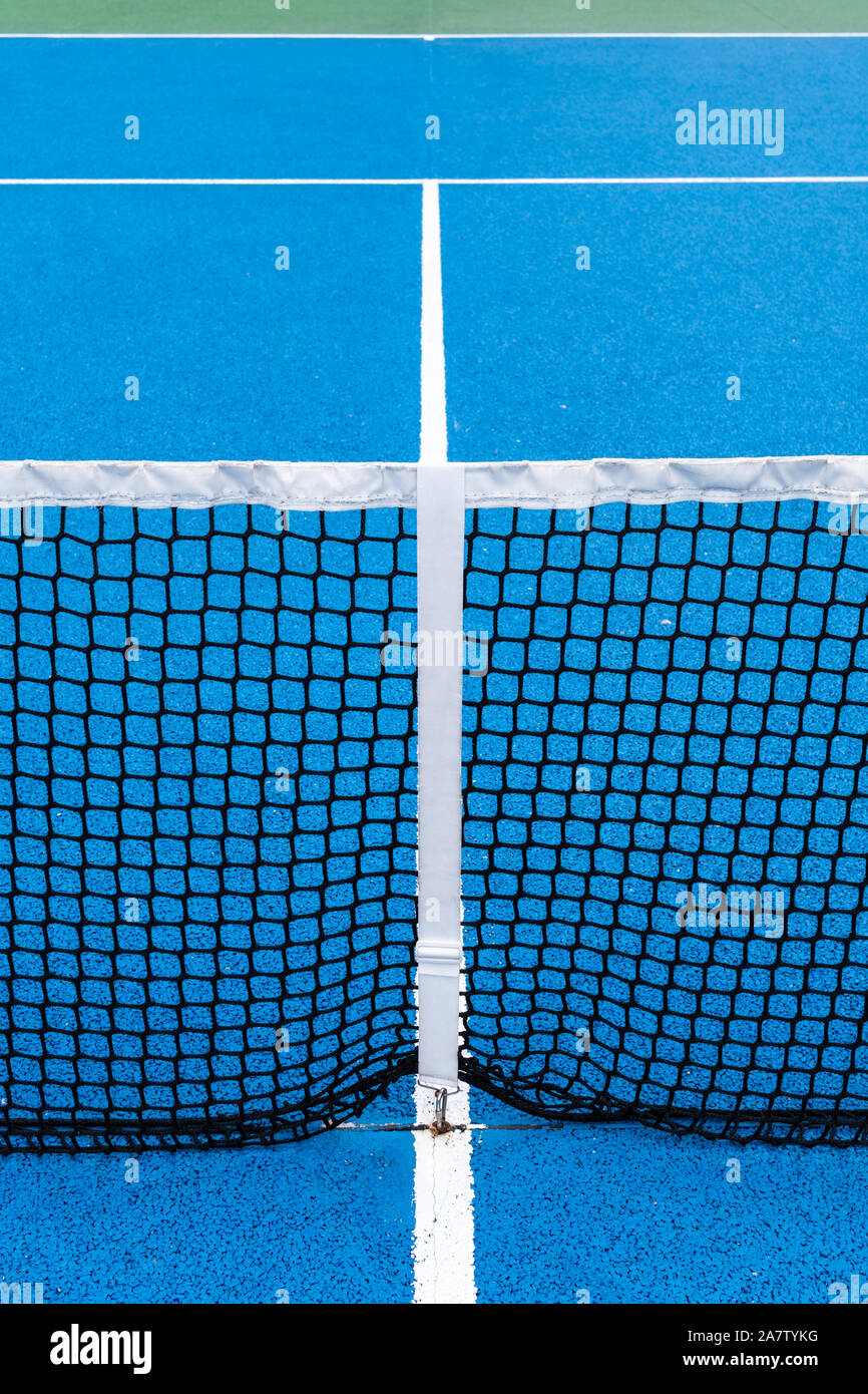 Detalle de una pista de tenis azul con negro net en el exterior. Antecedentes deportivos Foto de stock