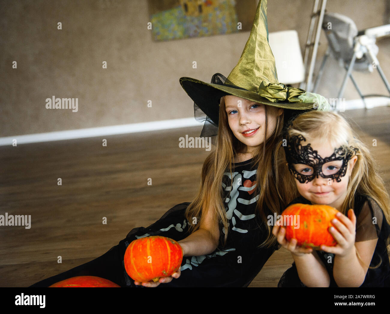 Dos Hermanas vestidas en trajes de esqueleto para Halloween con calabazas  Fotografía de stock - Alamy