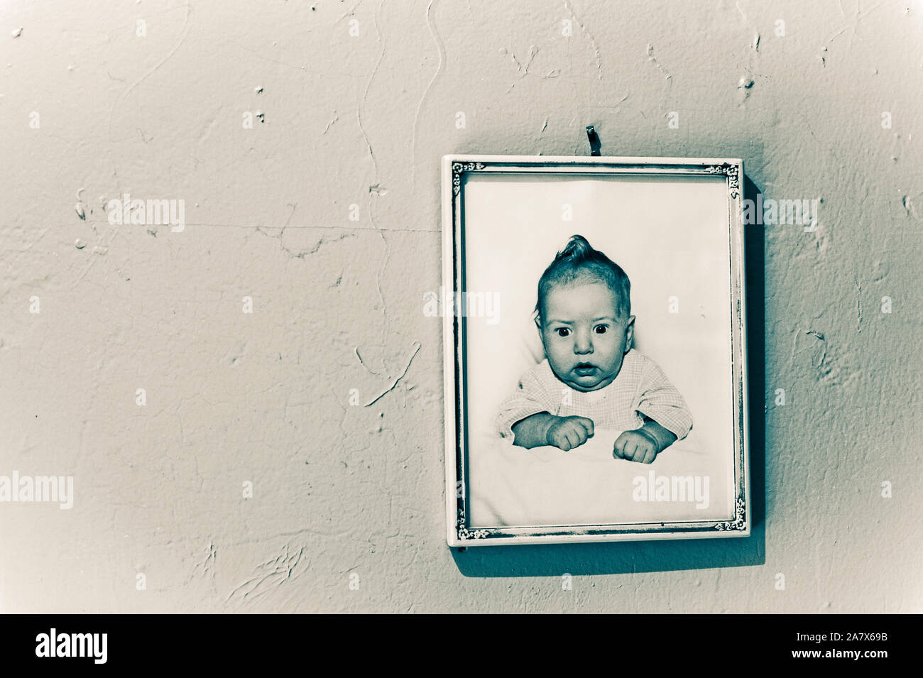 Cuadro de bebé enmarcado de los años 50 colgando en la pared. Foto de stock