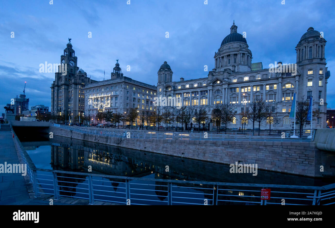 Las Tres Gracias de edificios, Royal Liver Building, Cunard Building y el puerto de Liverpool, edificio, visto por la noche en el Pier Head, en Liverpool Foto de stock