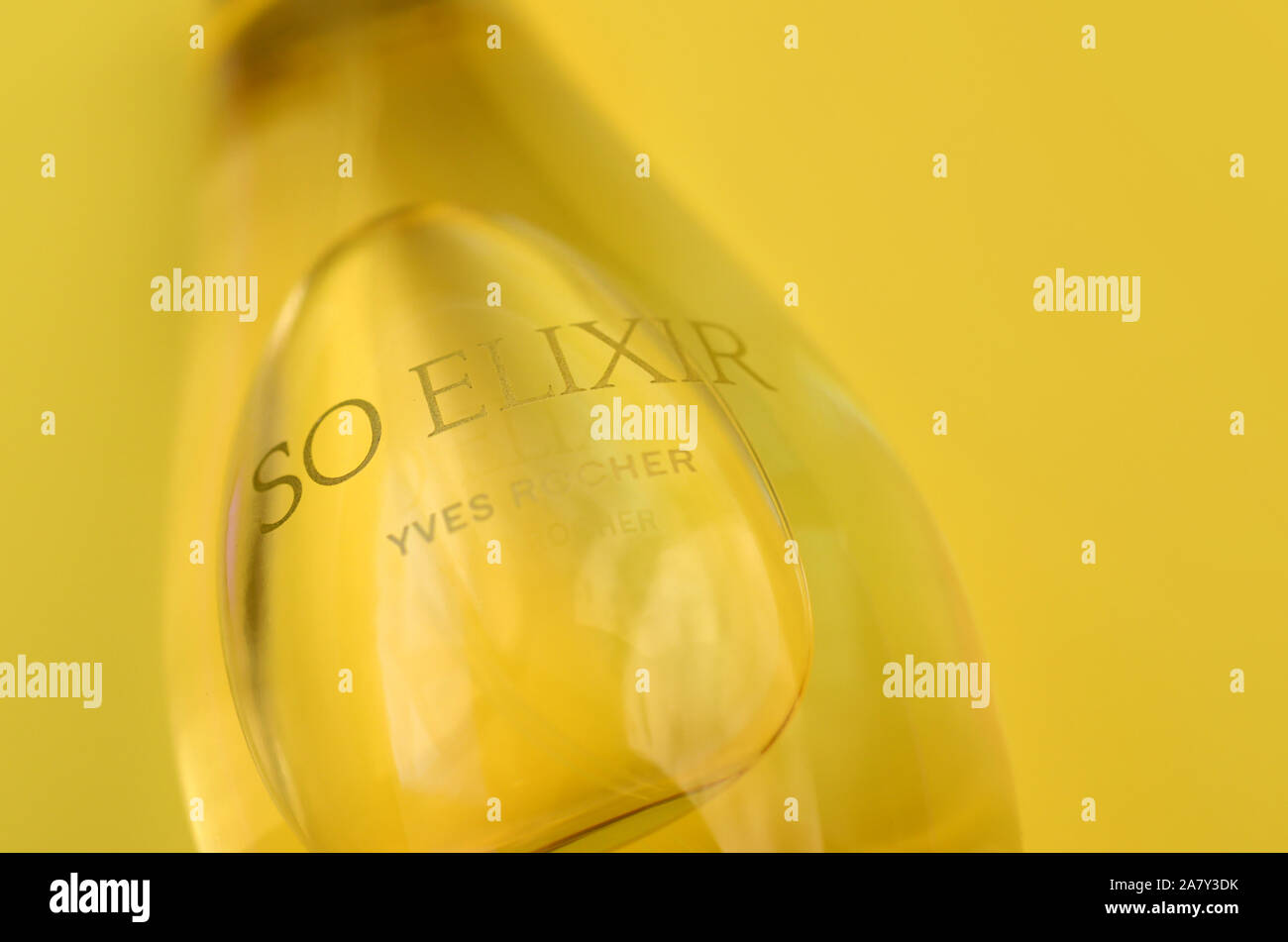 KHARKOV, Ucrania - 21 de octubre de 2019: botella de perfume Elixir por Yves Rocher sobre fondo de color amarillo brillante. Yves Rocher fue pionero de la moderna u Foto de stock