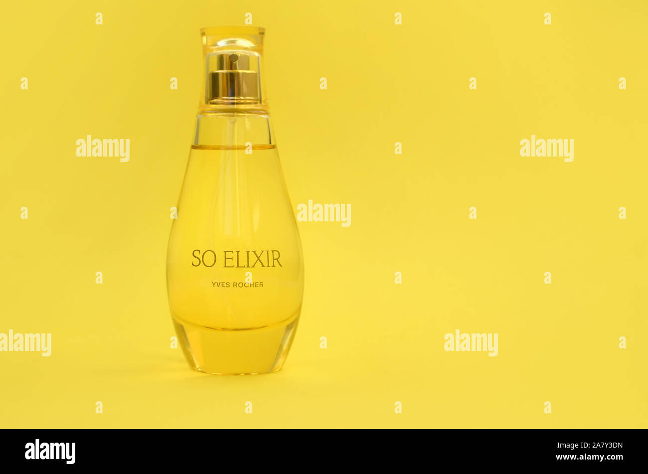 KHARKOV, Ucrania - 21 de octubre de 2019: botella de perfume Elixir por Yves Rocher sobre fondo de color amarillo brillante. Yves Rocher fue pionero de la moderna u Foto de stock