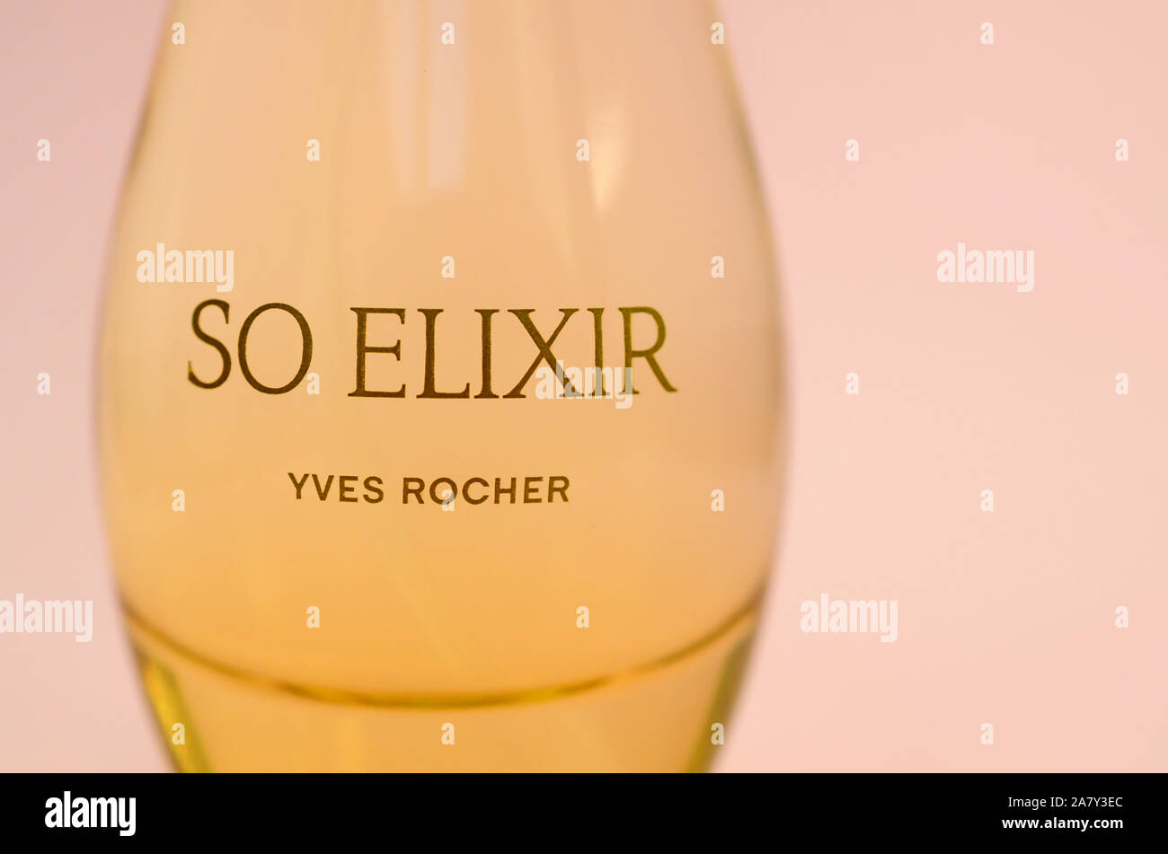 KHARKOV, Ucrania - 21 de octubre de 2019: botella de perfume Elixir por Yves Rocher sobre fondo de color rosa brillante. Yves Rocher fue pionero del uso moderno Foto de stock