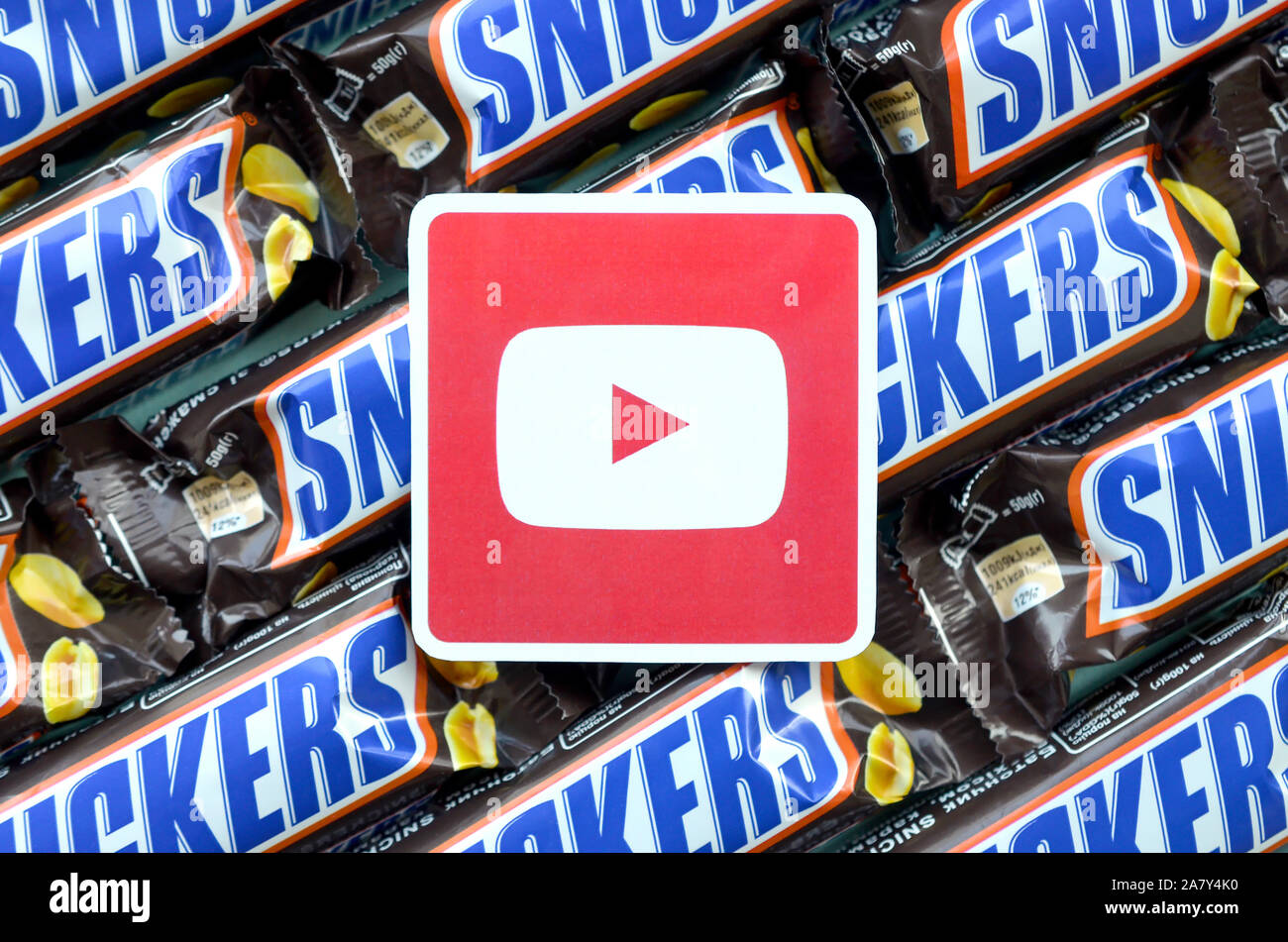 KHARKOV, Ucrania - Octubre 2, 2019: youtube logo de papel en muchos bares de obleas cubiertas de chocolate Snickers en embalaje marrón. La publicidad de productos de chocolate Foto de stock