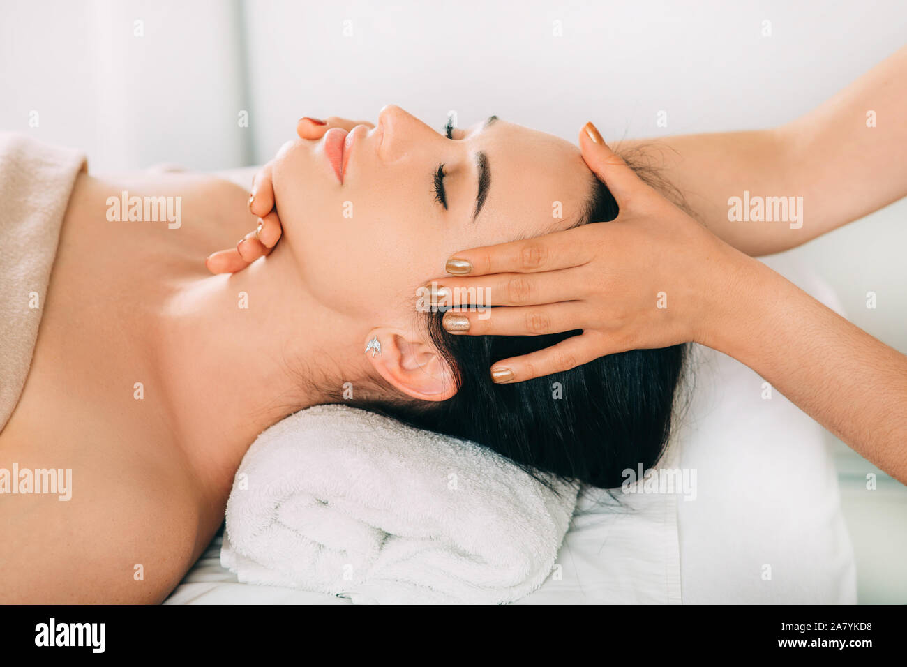 La mujer disfruta de masaje en la cabeza, la cara de cerca. Relajante masaje anti-estrés, dolor de cabeza Tratamiento Foto de stock