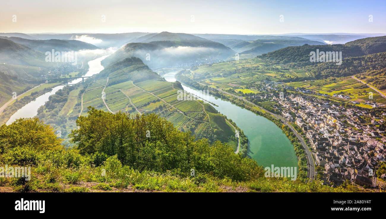 Curva del río Mosela, cerca de la aldea Bremm, Alemania, vista panorámica con nubes de niebla matutina sobre el valle del río Foto de stock