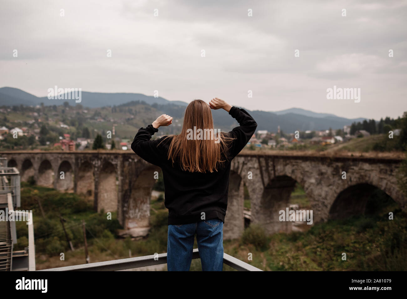 Mujer turista disfruta de viajar a lugares históricos en Ucrania, el viaducto en la aldea de Vorokhta resort de montaña, los Cárpatos. Concepto de viaje. Foto de stock